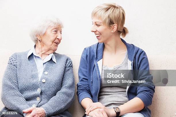 Jovem Mulher E Uma Mulher Idosa Sorridente E A Falar - Fotografias de stock e mais imagens de Terceira idade