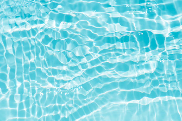 istock Blue water with ripples on the surface. Defocus blurred transparent blue colored clear calm water surface texture with splashes and bubbles. Water waves with shining pattern texture background. 1613344174