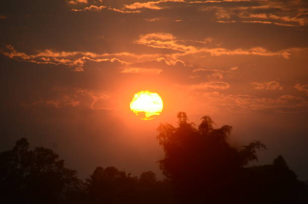 Scenic view dramatic beautiful sunset sky. Natural Sunset Sunrise on meadow silhouette shadow dark land. Vibrant dramatic sky on sunset, dawn, sunrise in Countryside. Landscape Colorful Sky At Sunset