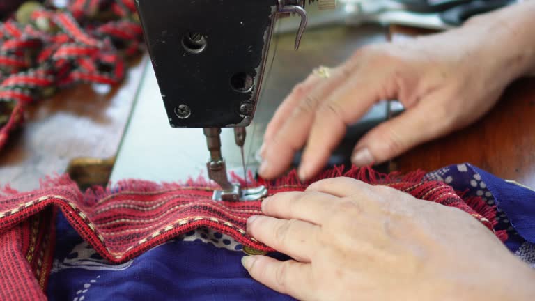 The video shows a seamstress demonstrating sewing, repairing clothes using an antique classic sewing machine for home use.