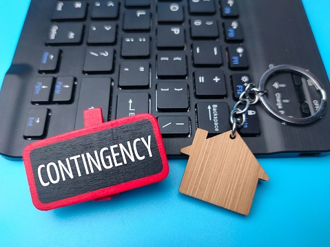 A sign with the word 'contingency' on a black keyboard background