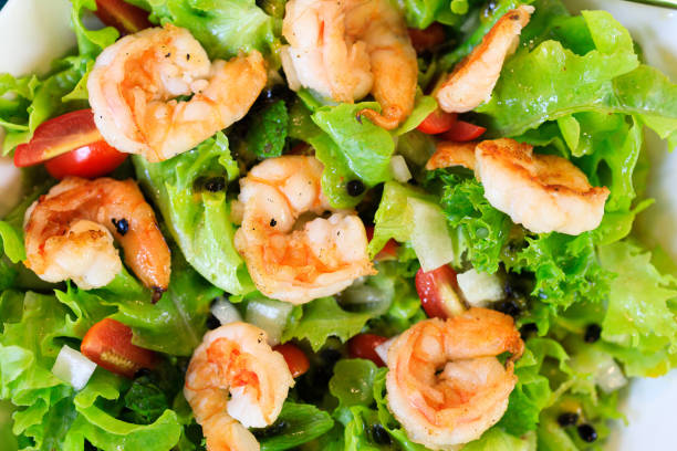 istock Boiled shrimp on green salad 1613433576