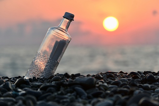 Paper in a glass bottle by the ocean