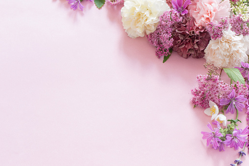istock beautiful summer flowers on pink paper background 1613463700