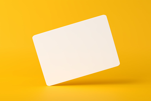 Mockup of a blank white business card hovering on yellow background. 3D render.