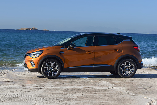 Saronida, Greece - 5th November, 2019: Modern crossover Renault Captur vehicles stopped next to the sea. This model is one of the most popular SUV/crossovers in Europe.