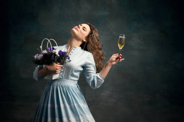 Queen. Dreaming aristocratic relaxing woman wearing blue historical dress and dancing with glass of shampange and bunch of flowers. Holiday mood. Dreaming aristocratic relaxing woman wearing blue historical dress and dancing with glass of shampagne and bunch of flowers. Concept of healthy lifestyle, diet, style, fashion. mirror women baroque style fashion stock pictures, royalty-free photos & images