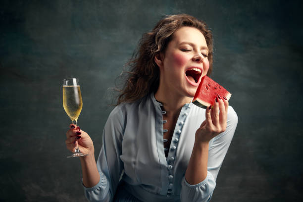 summer tastes. portrait of glamor hungry woman wearing blue historical dress going to take abite of slice of watermelon. food mood. - mirror women baroque style fashion imagens e fotografias de stock