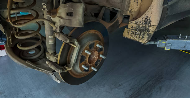 istock Car disc brake system. Car suspension in process of new tire replacement at garage workshop. Car disc brake mechanic check and repair. Disk break rotor. Car in change tire process at service station. 1613577862
