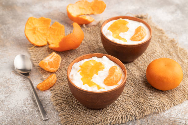 istock Grained cottage cheese with tangerine jam on brown concrete, side view. 1613582209
