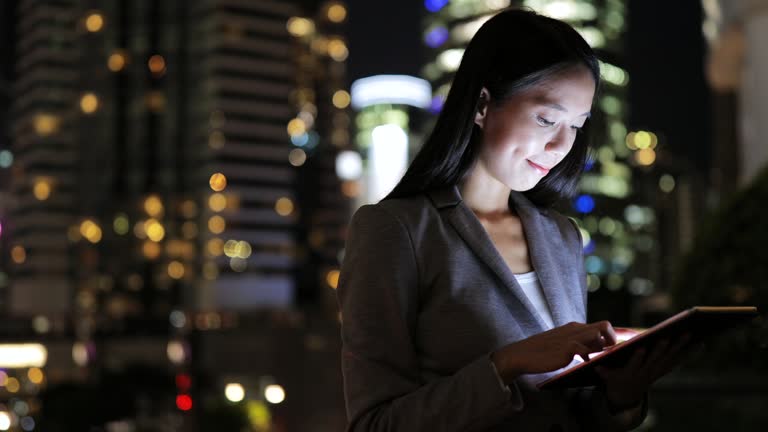 Business woman looking at digital tablet at night