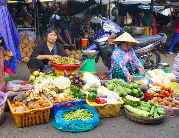 Hoi An, Vietnam - Sep 15, 2014. Fruit and vegetable vendors selling products at Hoi An market, Quang Nam, Vietnam. Hoi An is recognized as a World Heritage Site by UNESCO.