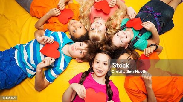 Group Of Kids Laying With Red Hearts Stock Photo - Download Image Now - Valentine's Day - Holiday, Child, Flooring