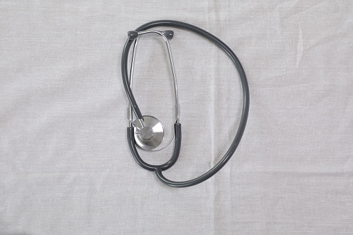 Stethoscope on white fabric background. Medical concept. Top view.