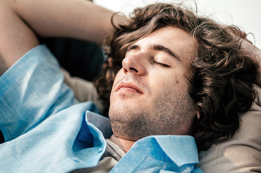 Portrait of a young man lying on a couch in office