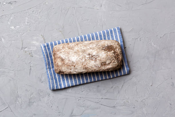 Fresh rye bread on napkin on rustic background, fresh bread top view