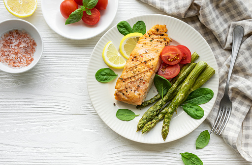 Baked Delicious salmon, green asparagus with vegetables on plate