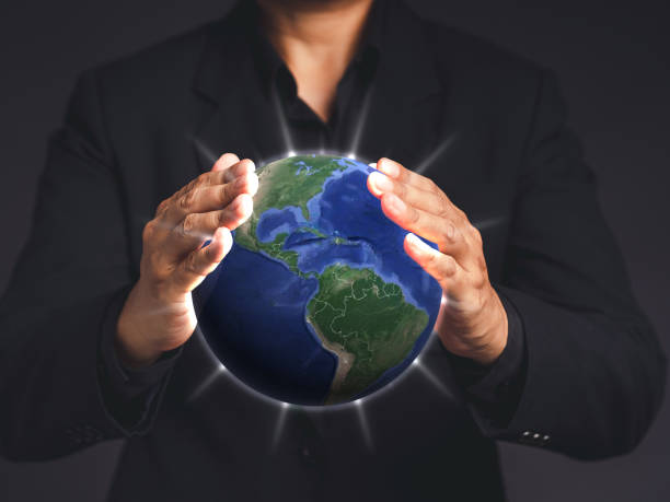 istock A businessman in a black suit hands protecting the earth on a virtual screen while standing on a gray background 1613642168