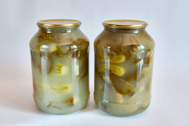 istock Glass jars with canned cucumbers on a white background. 1613642690