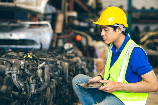 istock Engineer male worker check inventory store old used auto spare part engine gear part list for sale recycle in repair car garage market 1613647187