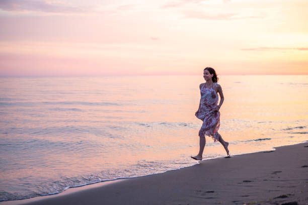 istock Happy woman running at the beach 1613647716