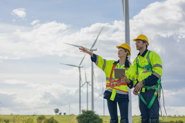 istock Engineer team man and woman field working together survey plan construction wind turbine clean power generator 1613647731