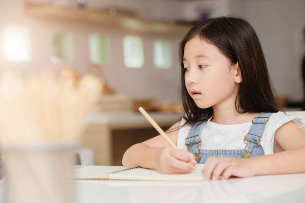 istock Cute child girl happy learning education doing home work at home holiday 1613648861