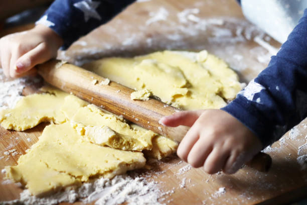 istock Little child making biscuit. child holding raw biscuit after use biscuit cutter. boy making Christmas Ester cookies for family in the kitchen. Hand holing biscuits before baking.Close up photo. person 1613651238