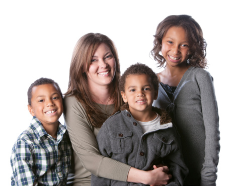 A waist up image of a mixed race family (Caucasian and African American) with mother, daughter and two sons.