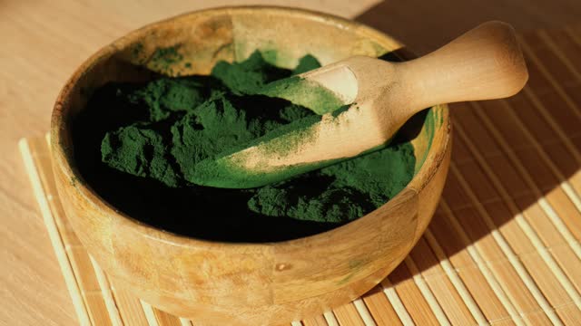 Blue-green algae Chlorella and spirulina powder in bamboo eco bowl. Super powder in spoon. Detox superfood. Natural supplement of algae
