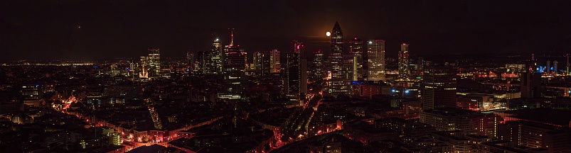 Drone panorama of Frankfurt skyline at night with full moon in summer