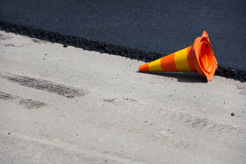 Hot And Freshly Paved Asphalt With Traffic Cone