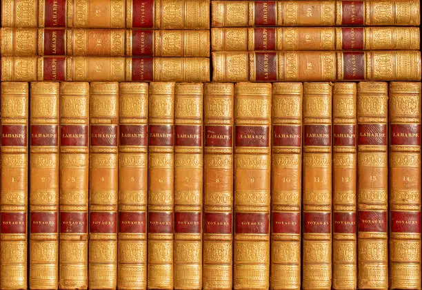 Old library background of leather-bound books with travelogues in luxurious gilt leather binding