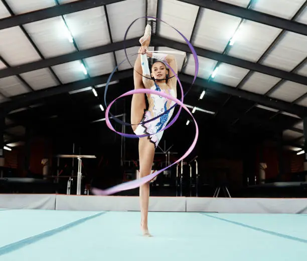 Photo of Portrait, ribbon and dance with a gymnastics woman in a studio for olympics training, exercise or dancing. Fitness, art and gymnast with a female dancer in a gymnasium for rhythmic practice