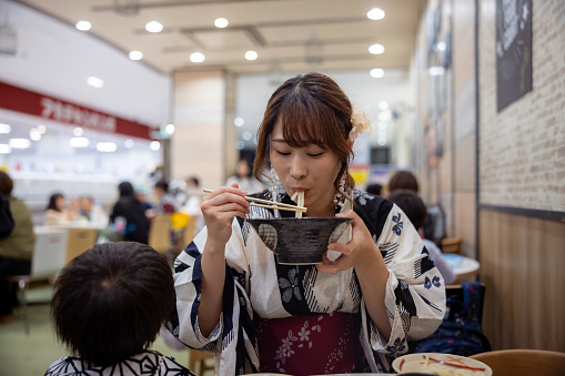 Woman in Yukata eating Udon noodle