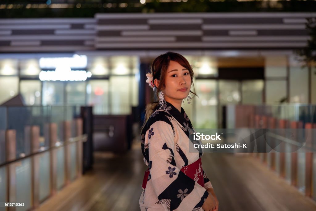 Portrait of beautiful woman in kimono standing in city at night 30-39 Years Stock Photo
