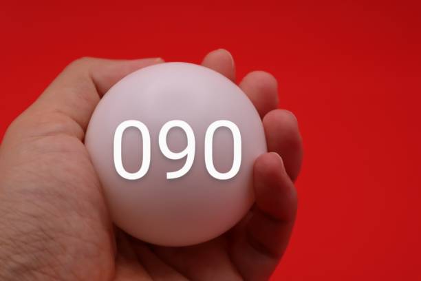 A person holding a ball with 090 written on it