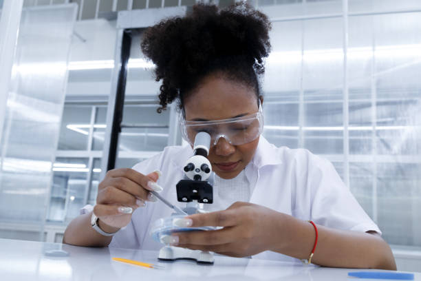 istock African female doctor student scientist looking microscope does analysis virus test sample. young biotechnology specialist working in lab. medical science laboratory hospital. 1613783702