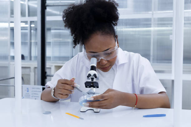 istock African female doctor student scientist looking microscope does analysis virus test sample. young biotechnology specialist working in lab. medical science laboratory hospital. 1613785328