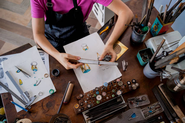 Young female jeweler making jewelry in workshop.