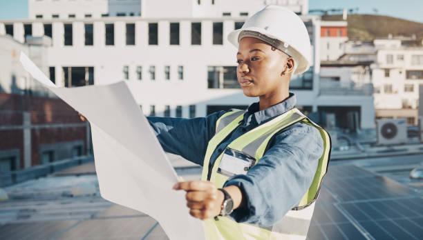 istock Female engineer, solar panel blueprint or outdoor on rooftop for power, sustainability plan or energy development. Black woman, photovoltaic tech or reading on roof, analysis or illustration in metro 1613792898