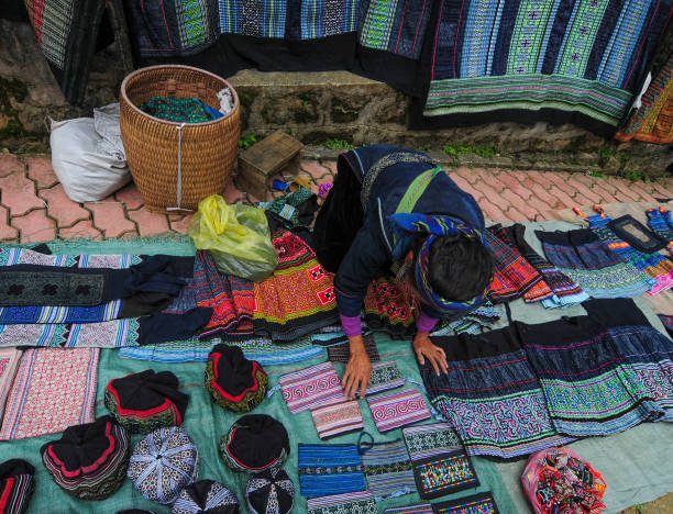 Selling ethnic clothes in Sapa, Vietnam Sapa, Vietnam - Sep 21, 2013. A woman selling Hmong clothes in Sapa, Northern Vietnam. Sa Pa is a town in northwest Vietnam not far from the Chinese border. bac ha market stock pictures, royalty-free photos & images