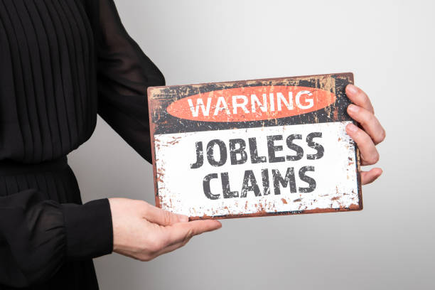 istock Jobless claims. Warning sign in woman's hand 1613800615