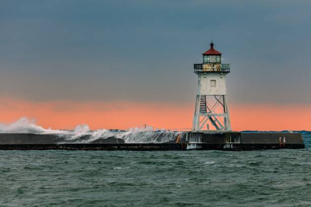 istock Grand Marais Lighthouse illuminated by a vibrant sunset, with the sky painted in deep oranges 1613802846