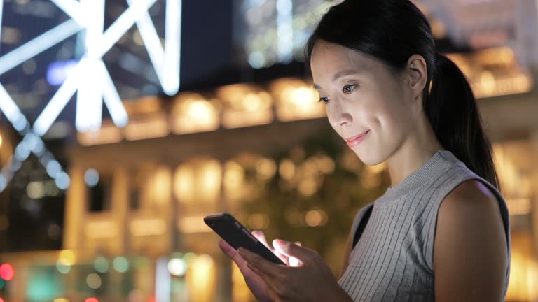 Woman looking at cellphone at night