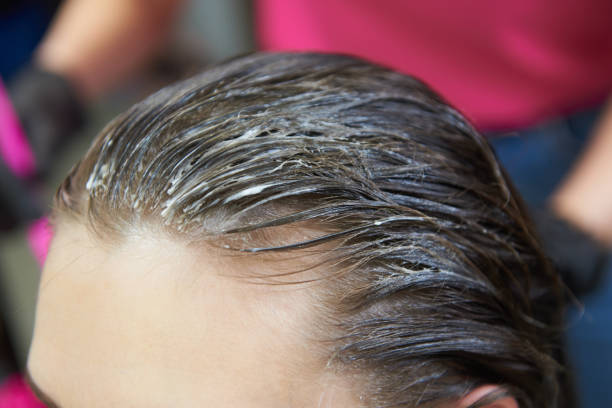 Female hair with applied bleach for hair dye stock photo