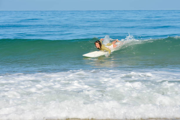Portrait of a pretty athletic female surfer in a wetsuit