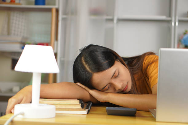istock Asian woman sleeping on her desk at home 1613844599