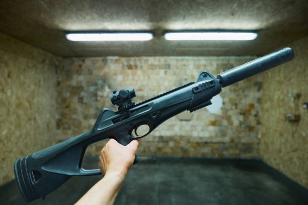 istock Futuristic Italian rifle with a red dot in hand in a shooting range. 1613864704