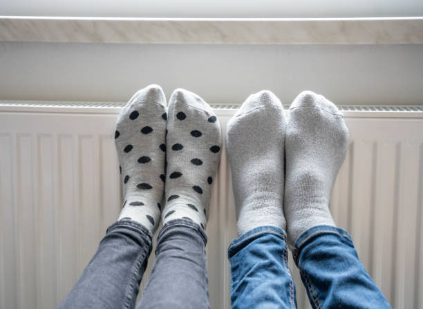 istock Family warming legs on heating radiator 1613871800